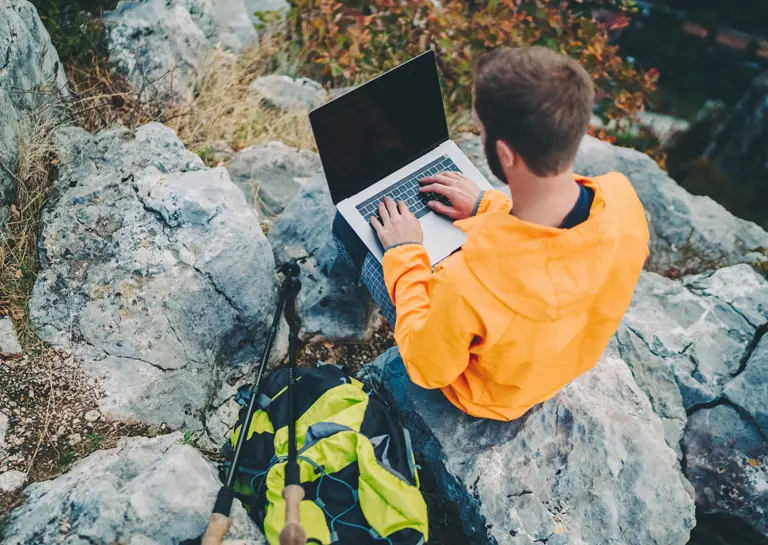 Mężczyzna przy laptopie w górach